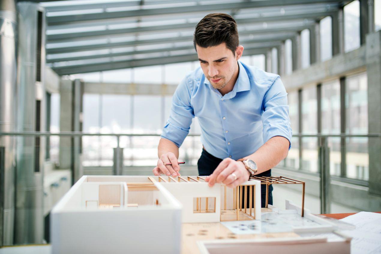 Ein angehender Energieberater analysiert ein Architekturmodell während seiner Energieberater Ausbildung.